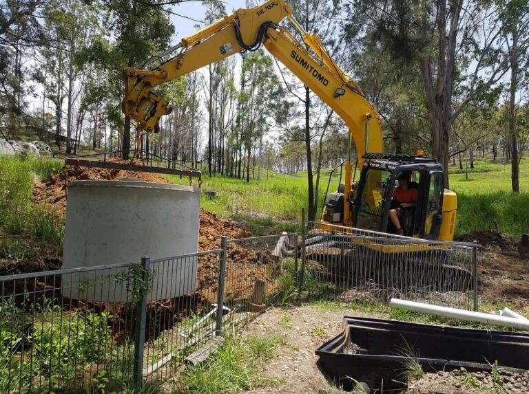 Excavator truck pulling a concrete septic tank — Precast Concrete Products Near Me in Yamba, NSW