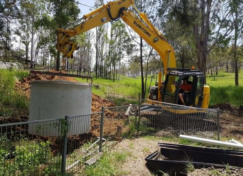 Excavator truck pulling a concrete septic tank — Precast Concrete Products Near Me in Yamba, NSW